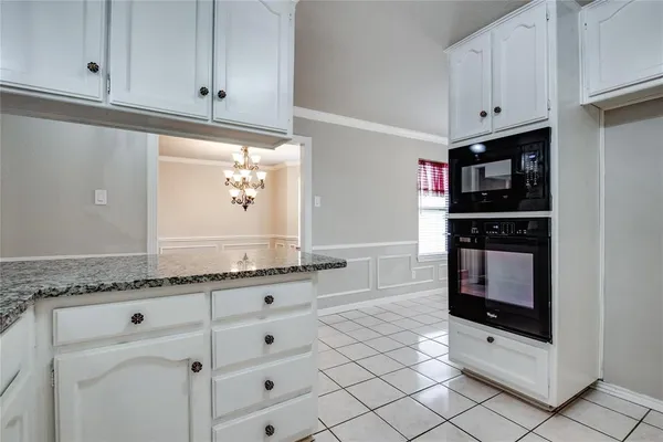 a kitchen with granite countertop white cabinets and white appliances