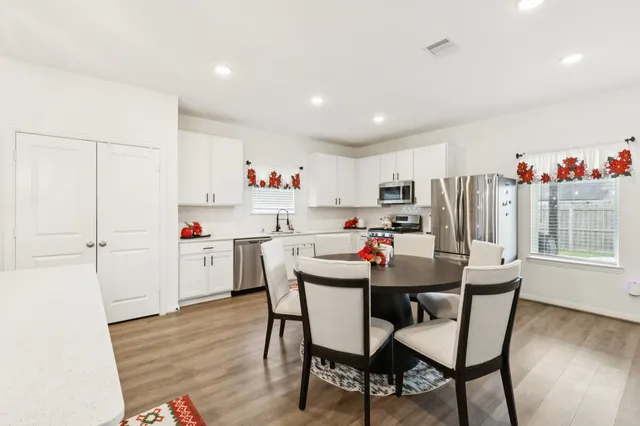 a kitchen with kitchen island a appliances dining table and chairs