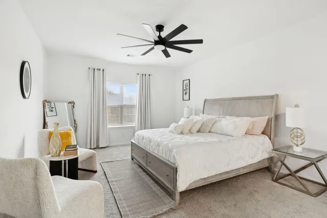 a bedroom with a bed a window and ceiling fan