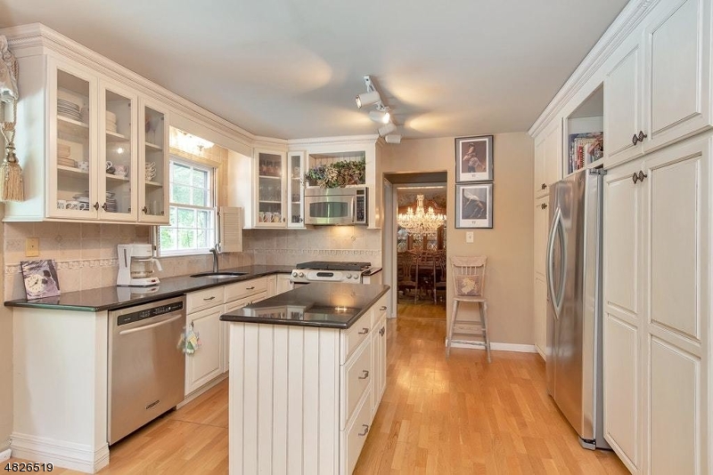 517 High Street Stirling, NJ 07980 - Photo 7 of 22 a kitchen with stainless steel appliances granite countertop a refrigerator a sink dishwasher a stove and white countertops with wooden floor
