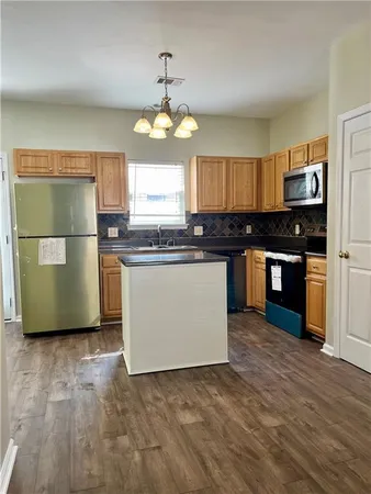 a kitchen with stainless steel appliances granite countertop a stove top oven a refrigerator a sink and dishwasher