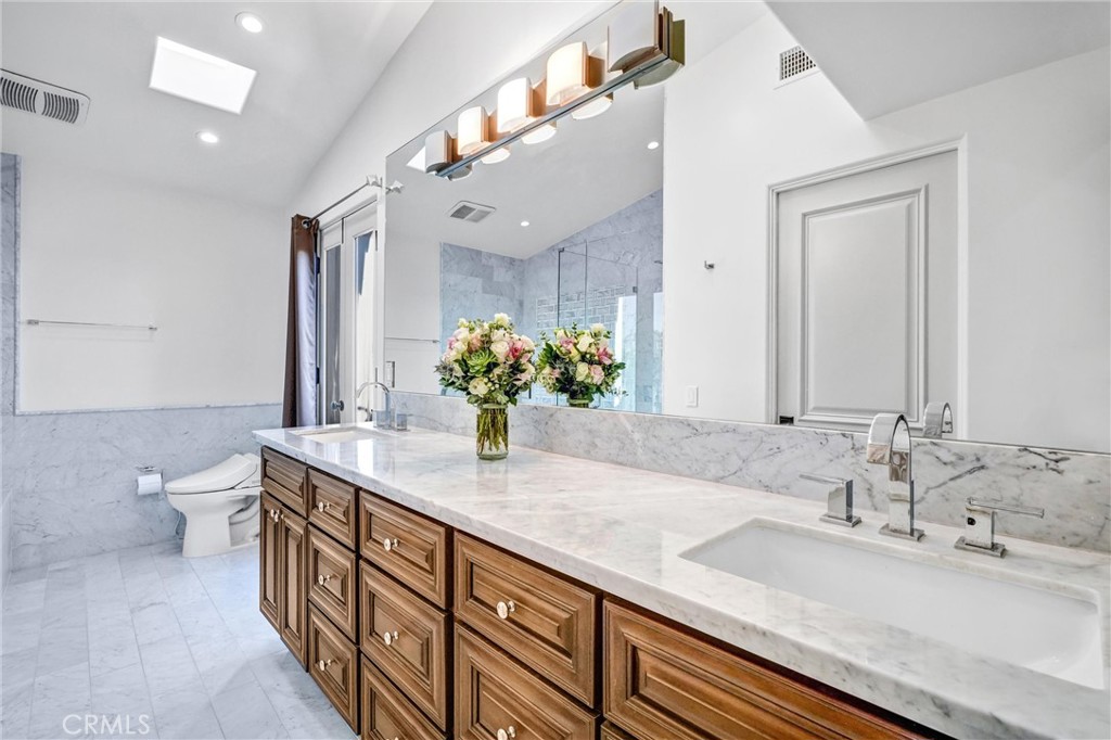 18228 Grevillea Avenue Redondo Beach, CA 90278 - Photo 23 of 39 a bathroom with a granite countertop sink a toilet and a mirror