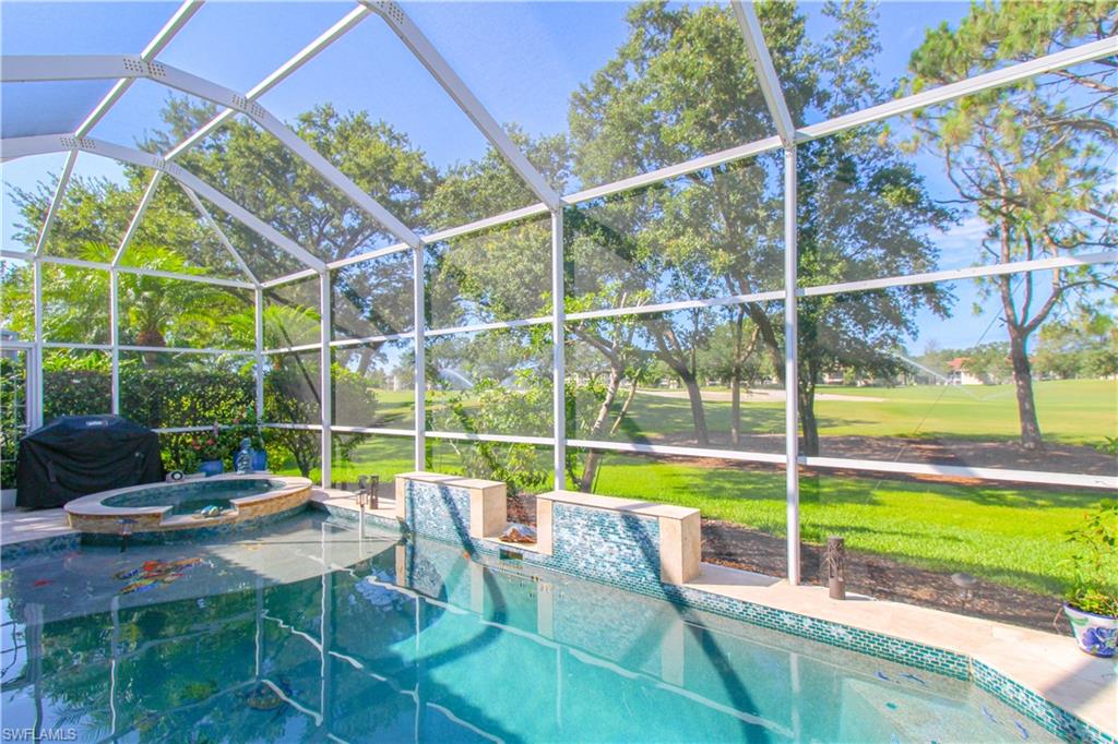 152 Napa Ridge Way Naples, FL 34119 - Photo 14 of 50 a view of a swimming pool with a patio and a yard