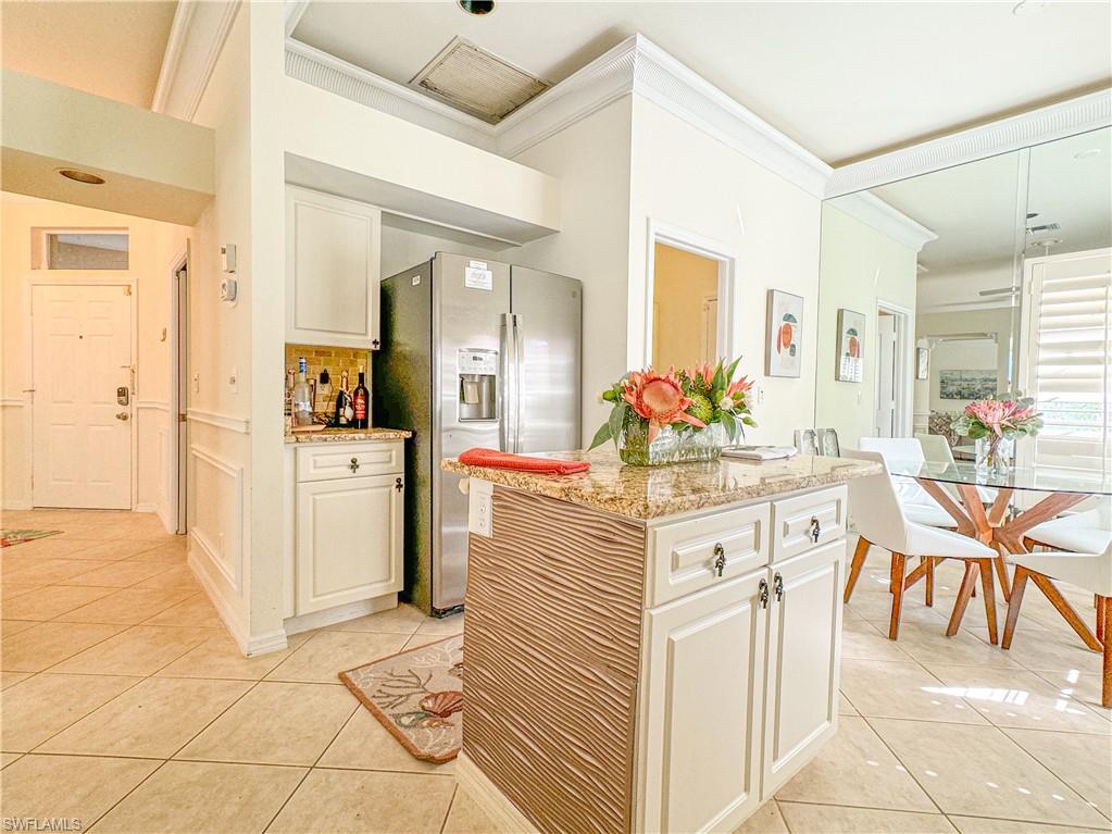 152 Napa Ridge Way Naples, FL 34119 - Photo 36 of 50 a kitchen with stainless steel appliances kitchen island granite countertop a table and chairs in it