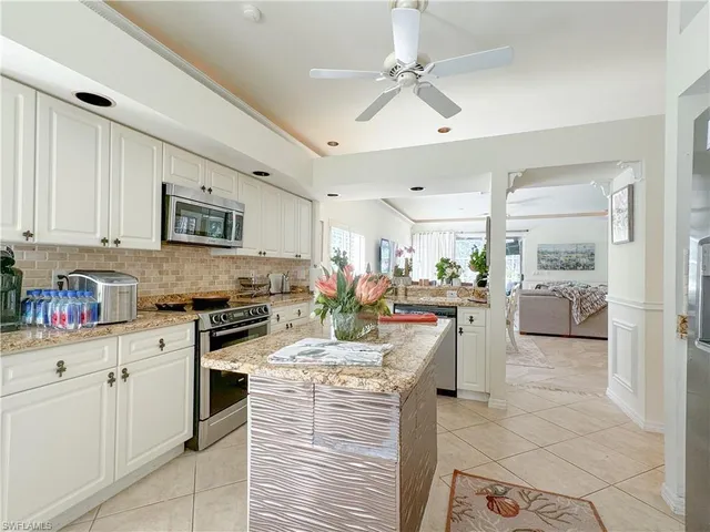 a kitchen with stainless steel appliances kitchen island granite countertop a sink and cabinets
