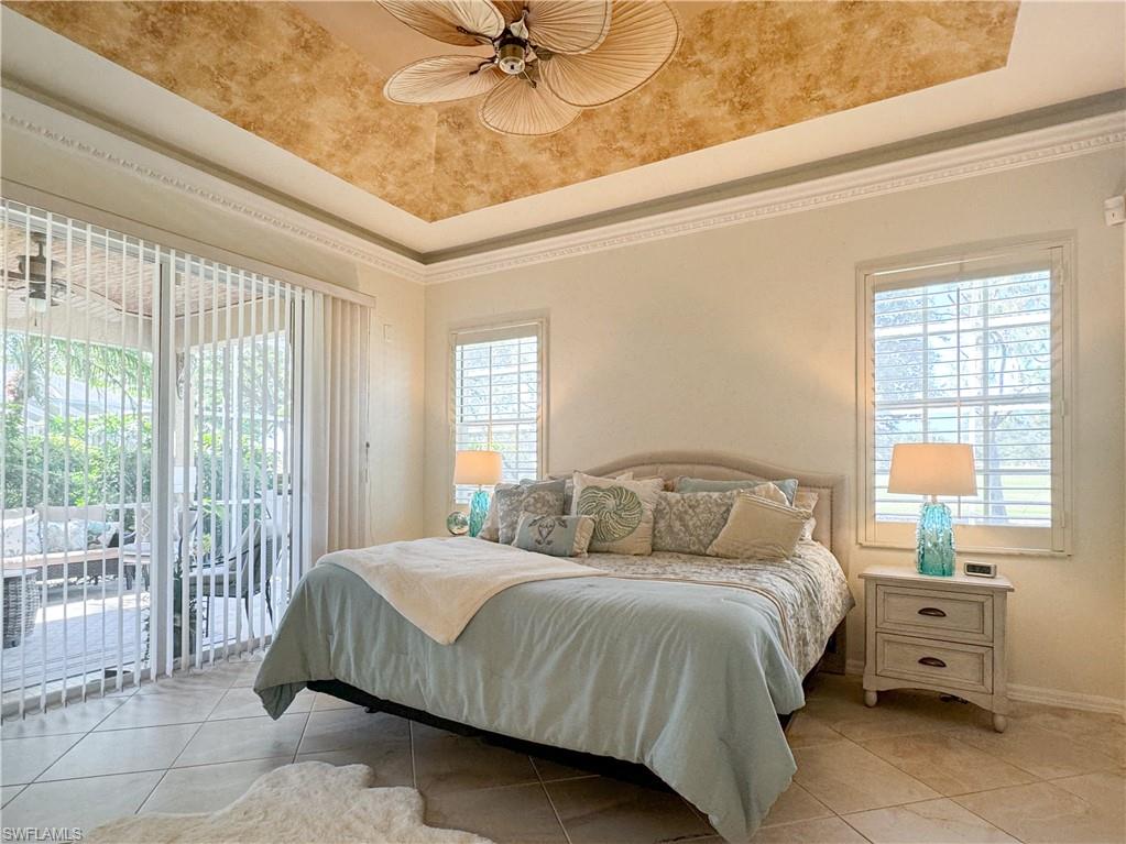 152 Napa Ridge Way Naples, FL 34119 - Photo 44 of 50 a bedroom with a bed and a chandelier