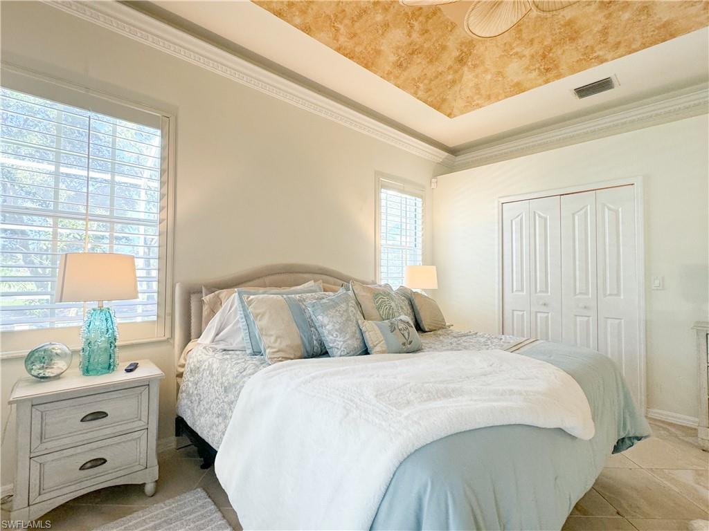 152 Napa Ridge Way Naples, FL 34119 - Photo 46 of 50 a bedroom with a bed and a lamp