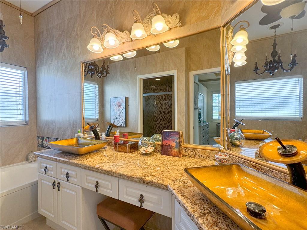 152 Napa Ridge Way Naples, FL 34119 - Photo 48 of 50 a bathroom with a granite countertop sink and a large mirror