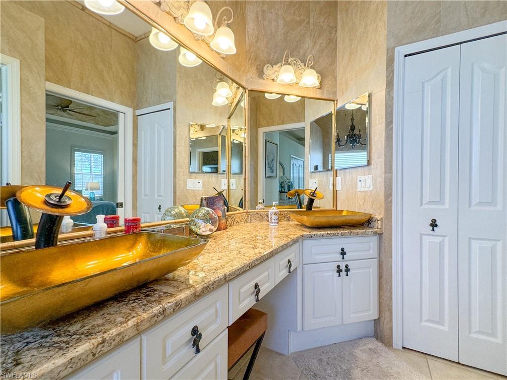 152 Napa Ridge Way Naples, FL 34119 - Photo 49 of 50 a bathroom with a granite countertop sink and a mirror