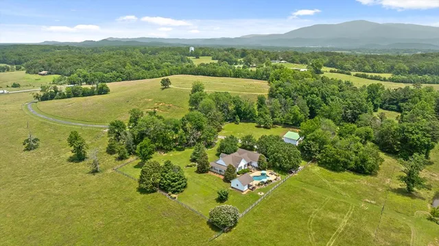 a view of a house with swimming pool and chairs