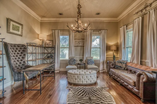 a living room with furniture a chandelier and a rug