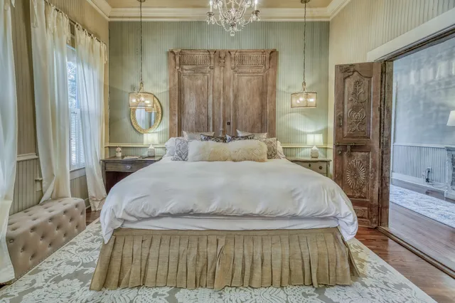 a bedroom with a bed and a chandelier