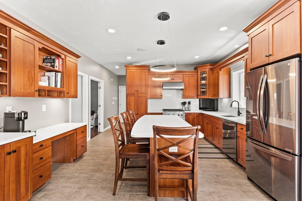 20 Mohawk Road Raynham, MA 02767 - Photo 13 of 42 a kitchen with stainless steel appliances granite countertop a refrigerator a sink dishwasher a dining table and chairs with wooden floor