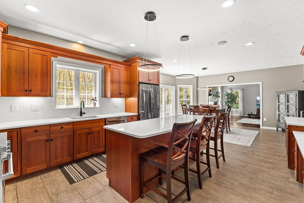 20 Mohawk Road Raynham, MA 02767 - Photo 10 of 42 a kitchen with stainless steel appliances kitchen island granite countertop a table chairs and wooden cabinets