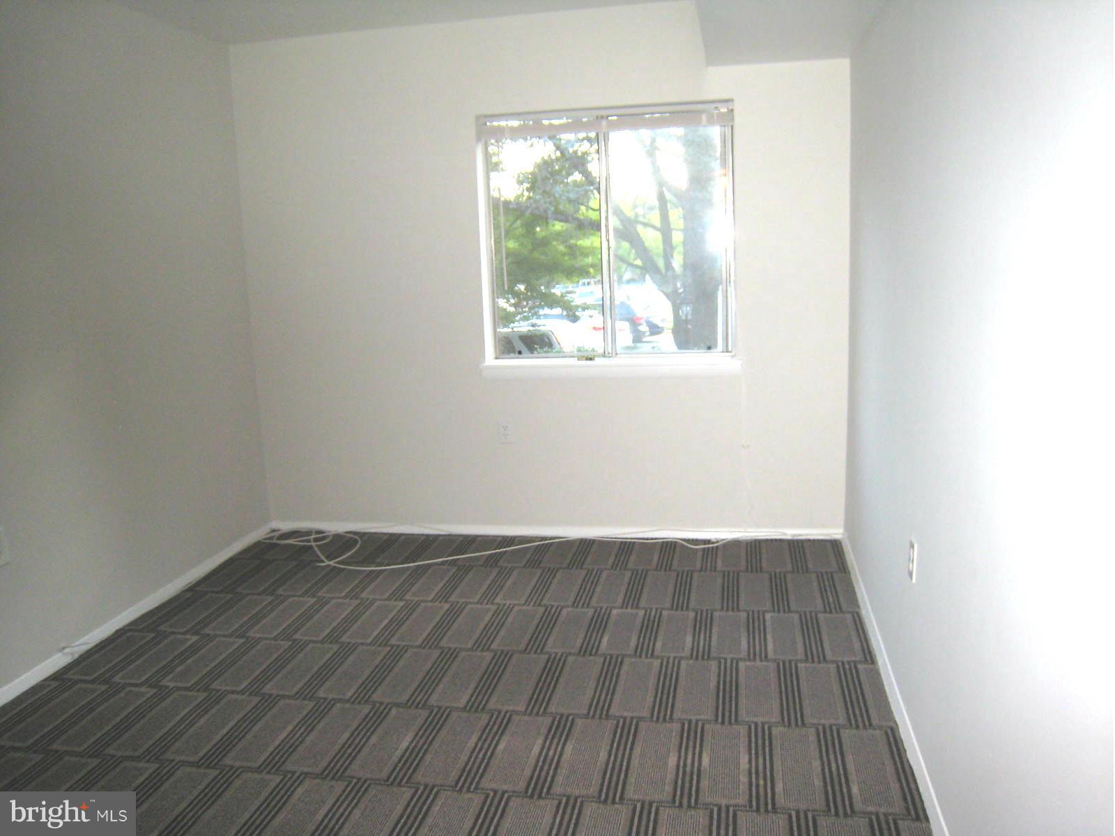 18610 Walkers Choice Road, Unit 4 Gaithersburg, MD 20886 - Photo 7 of 15 an empty room with wooden floor and windows