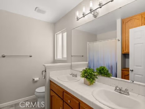 11191 Baker Lane Riverside, CA 92505 - Photo 26 of 49 a bathroom with a sink a toilet and mirror