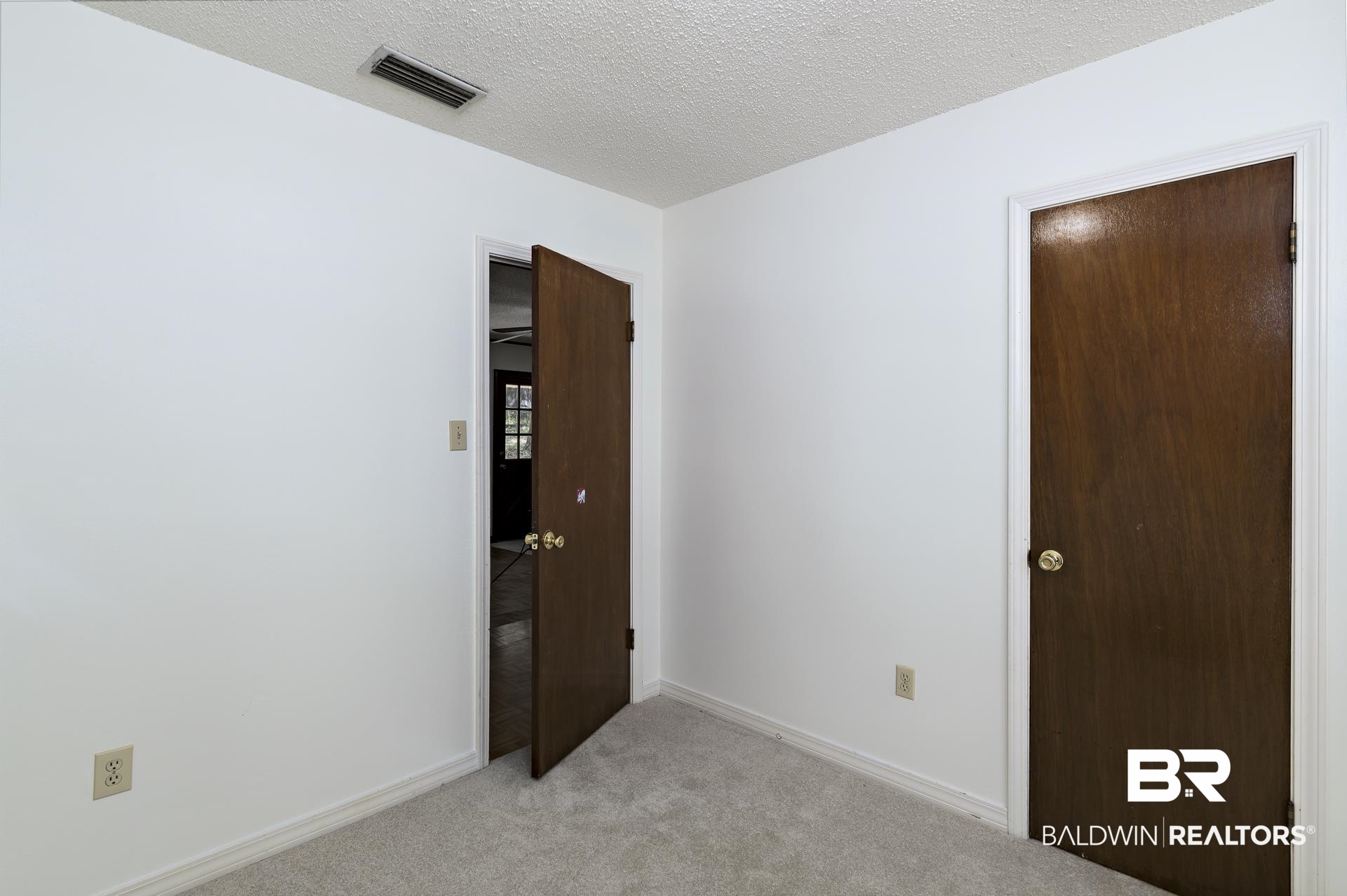 707 Johnson Avenue Fairhope, AL 36532 - Photo 30 of 38 Empty room featuring visible vents, baseboards, light carpet, and a textured ceiling