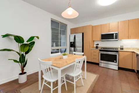 a kitchen with stainless steel appliances a stove a table and chairs