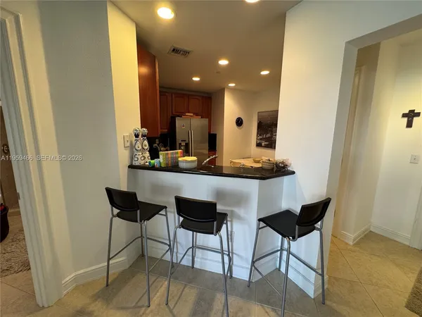 a dining room with kitchen island furniture a sink and a mirror