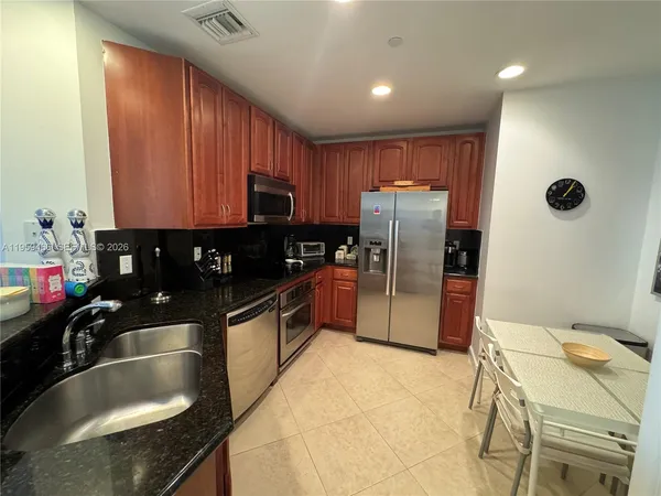 a kitchen with stainless steel appliances granite countertop a sink a stove and a refrigerator