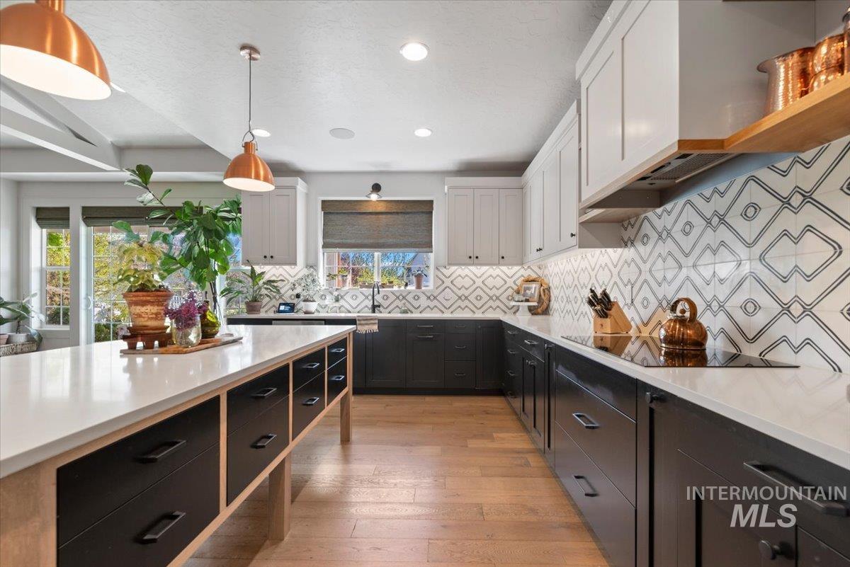 15164 Pinehurst Way Caldwell, ID 83607 - Photo 18 of 50 Kitchen featuring a central island with integrated storage, white countertops, two-tone cabinetry, patterned tile backsplash, and recessed lighting