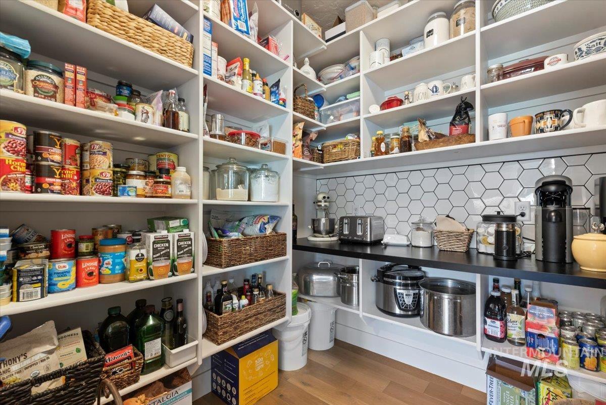15164 Pinehurst Way Caldwell, ID 83607 - Photo 20 of 50 Spacious pantry featuring extensive shelving, a durable black countertop, and a white hexagonal tile backsplash