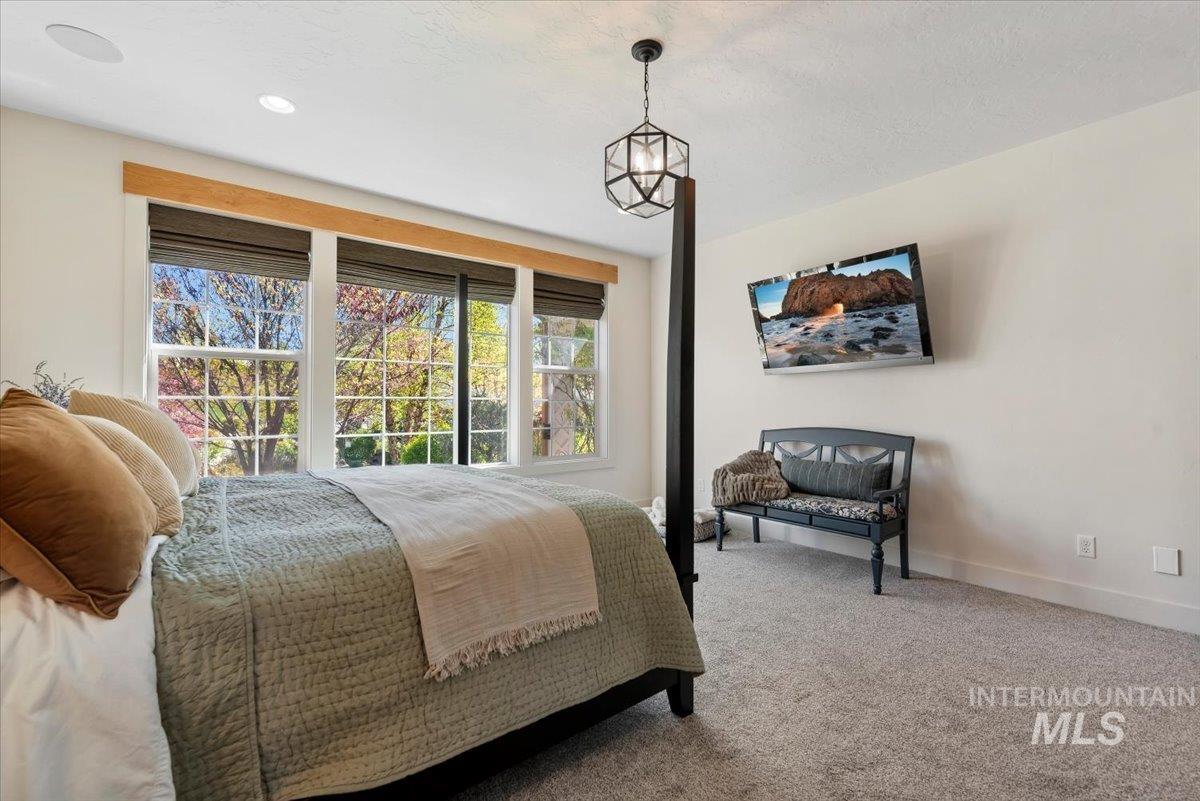 15164 Pinehurst Way Caldwell, ID 83607 - Photo 23 of 50 Inviting bedroom featuring expansive windows, recessed ceiling lighting, a contemporary geometric pendant light, soft wall-to-wall carpeting, and a wall-mounted display