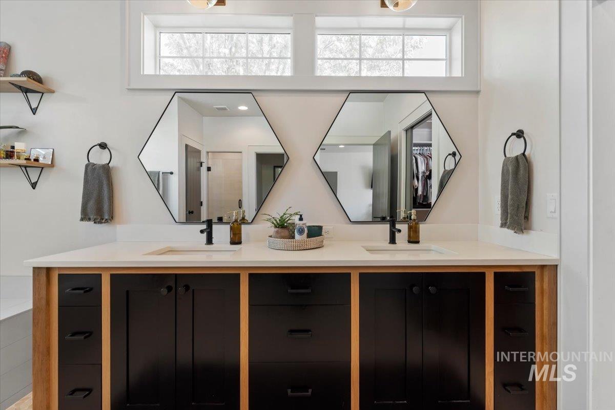 15164 Pinehurst Way Caldwell, ID 83607 - Photo 24 of 50 Double vanity with black cabinetry, wood-finish accents, and a light-toned countertop
