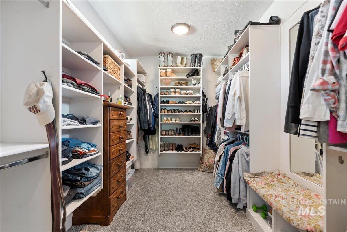 15164 Pinehurst Way Caldwell, ID 83607 - Photo 28 of 50 Walk-in closet featuring built-in shelving, hanging rods, an integrated shoe rack, a wooden drawer unit, and carpet flooring