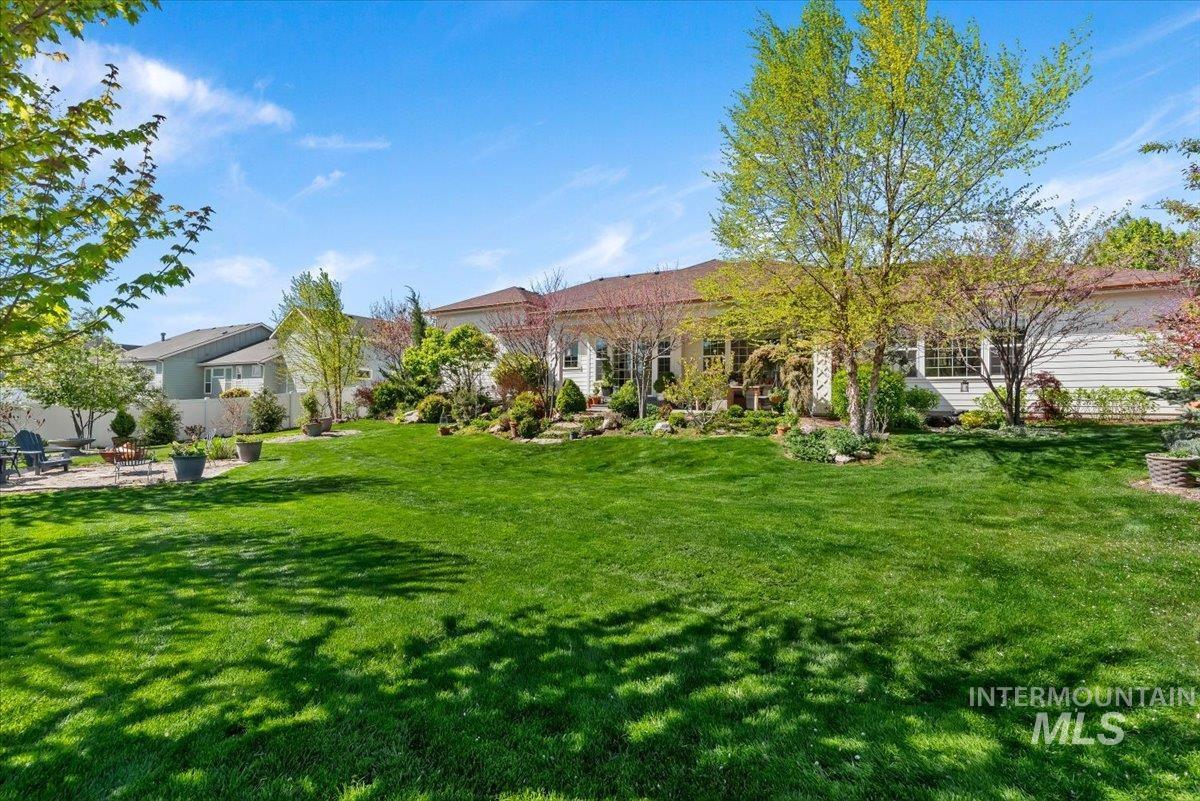 15164 Pinehurst Way Caldwell, ID 83607 - Photo 42 of 50 Expansive backyard featuring a manicured lawn, established trees, and structured landscaping