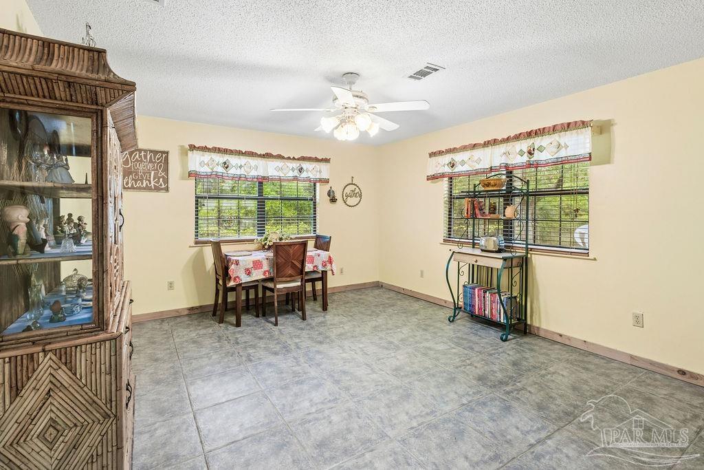 8938 Pioneer Road Holt, FL 32564 - Photo 11 of 44 a dining room with furniture and a chandelier