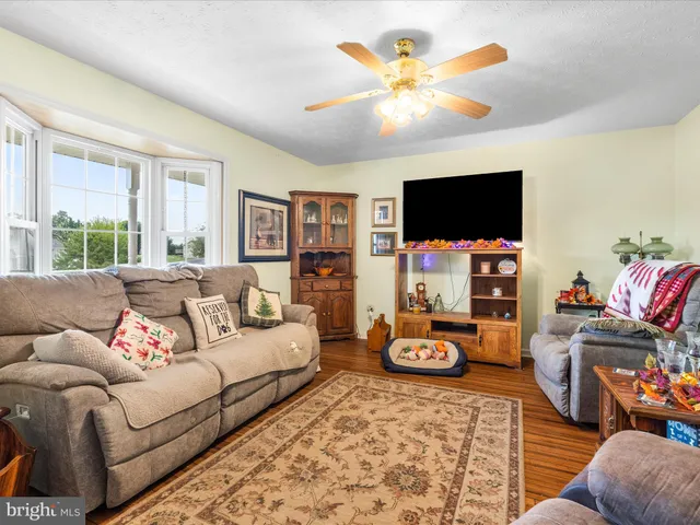 a living room with furniture a flat screen tv and a window