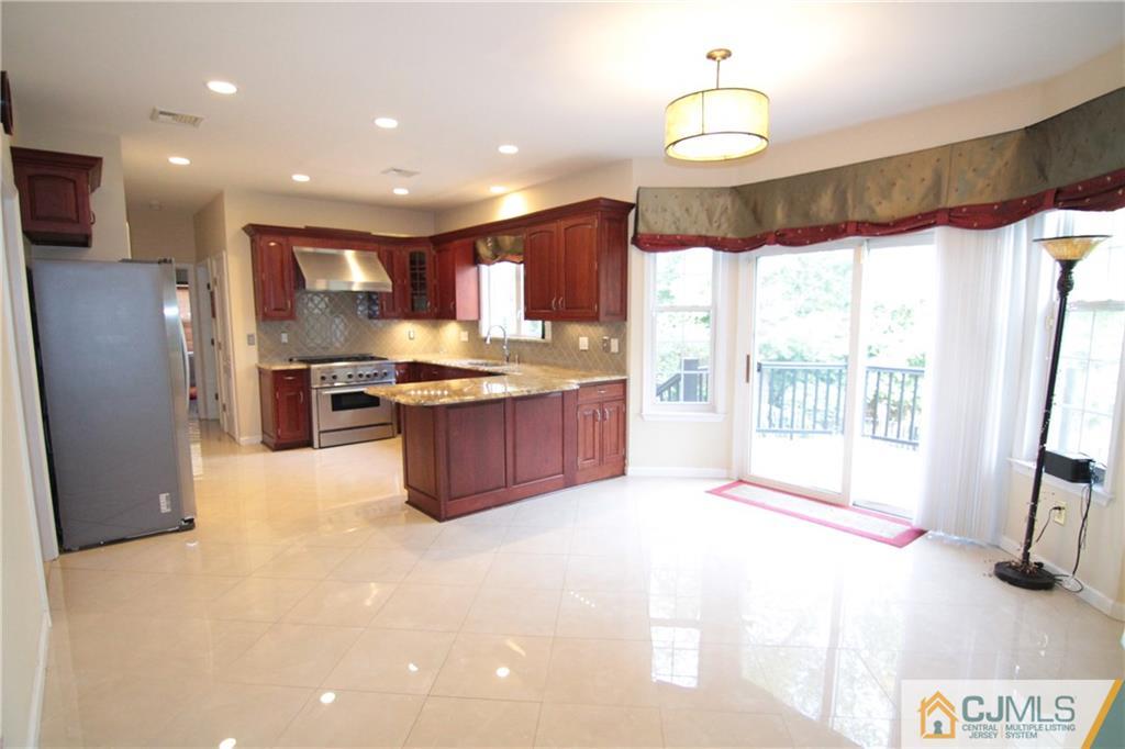 15 Gramercy Road Monmouth Junction, NJ 08852 - Photo 3 of 17 a kitchen with stainless steel appliances granite countertop a refrigerator a sink a stove and a granite counter tops