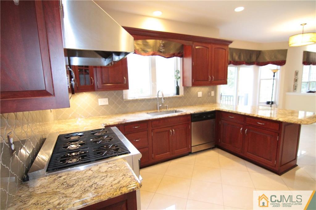 15 Gramercy Road Monmouth Junction, NJ 08852 - Photo 4 of 17 a kitchen with stainless steel appliances granite countertop a stove a sink and a microwave