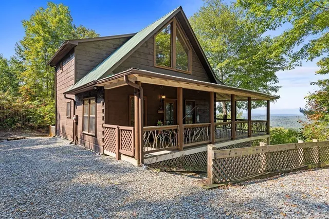 a view of a house with a small yard and wooden fence