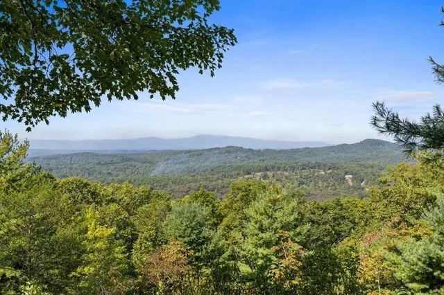 a balcony with wooden floor table and chairs