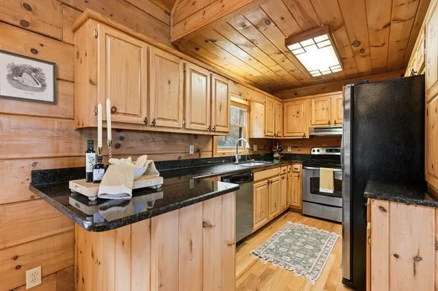 a kitchen with stainless steel appliances granite countertop a sink a stove and cabinets