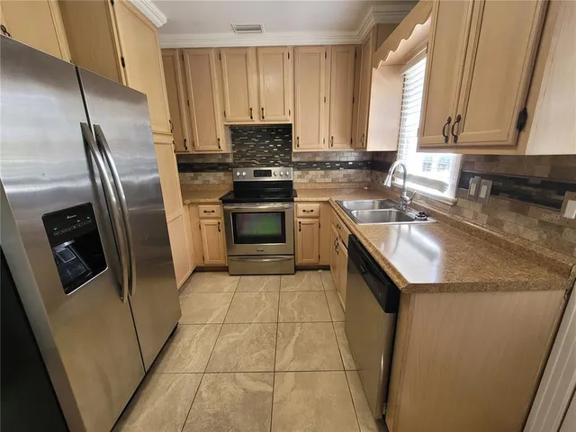 a kitchen with stainless steel appliances granite countertop a sink stove microwave and refrigerator