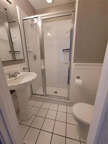 a bathroom with a sink a toilet a mirror and shower