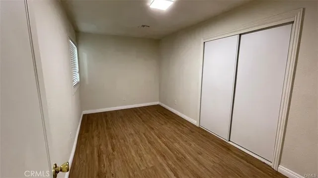 an empty room with wooden floor and sliding door