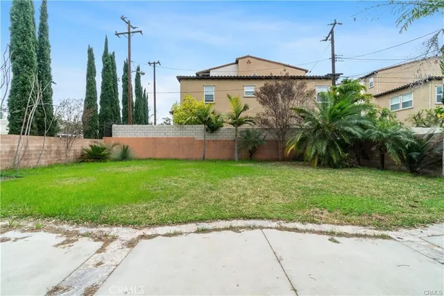 a front view of a house with a yard and potted plants