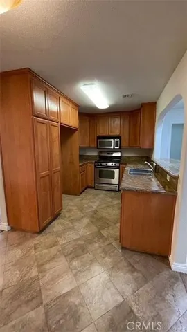 a kitchen with stainless steel appliances granite countertop a refrigerator and a stove top oven