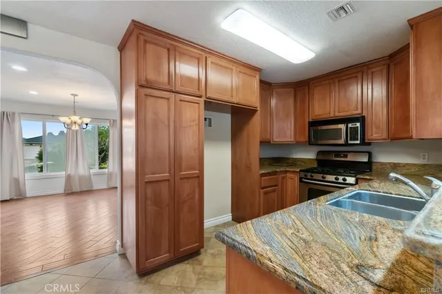 a kitchen with granite countertop stainless steel appliances and wooden cabinets
