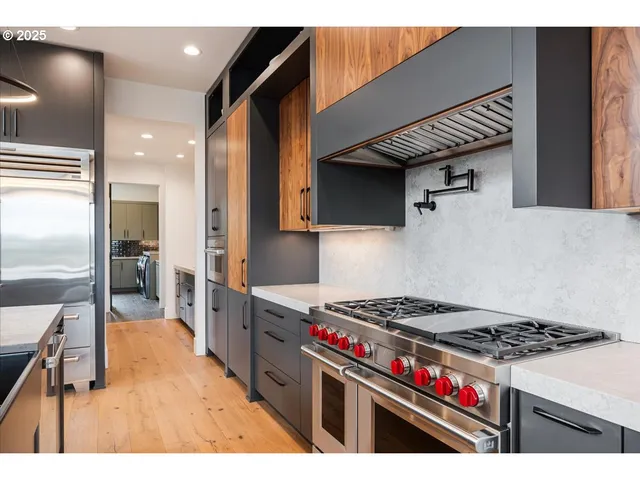 a kitchen with stainless steel appliances granite countertop a stove a sink and a refrigerator