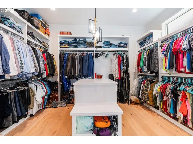 a view of walk in closet with clothes and shoes