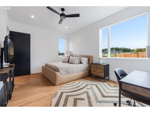 a bedroom with a bed window and a flat screen tv