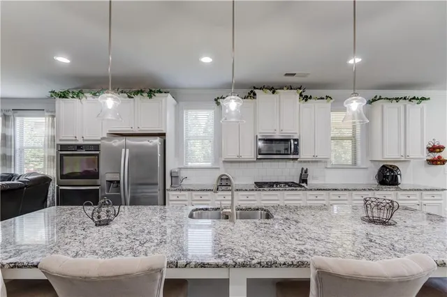 a kitchen with kitchen island granite countertop a sink stove and refrigerator