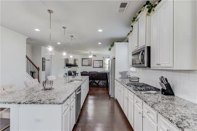 a kitchen with stainless steel appliances granite countertop sink stove and refrigerator