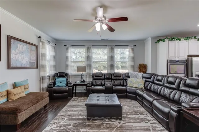 a living room with furniture ceiling fan and a window