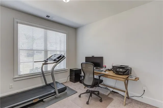 a view of a workspace with furniture and a window